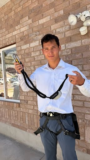 Put on the harness and hold the lanyard